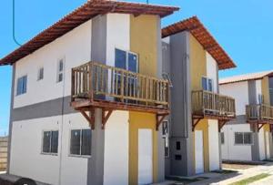a yellow and white building with a balcony at Maramarbh43 in Luis Correia