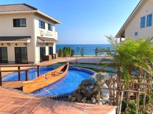 a boat in a swimming pool next to a building at Love&Peace Resort in Shima