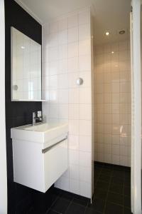 een witte badkamer met een wastafel en een spiegel bij Gouden Plakje in Gaastmeer