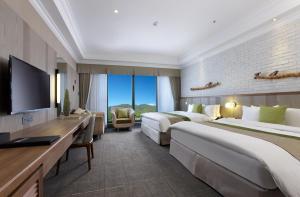 a hotel room with two beds and a flat screen tv at Yang Ming Shan Tien Lai Resort & Spa in Jinshan