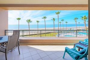 a room with a view of the beach and palm trees at Oceanfront Sunsets at Sonoran Spa E305 in Puerto Peñasco