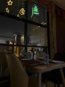 a table in a restaurant with a view of the city at Midhal Al Ezz Ajyad Hotelفندق مدهال العز in Mecca