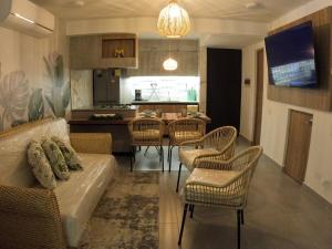 a living room with a couch and chairs and a kitchen at Casa Yireth in Ricaurte