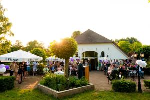 Une foule de gens se tenant devant un bâtiment blanc dans l'établissement Sistazz Bed&Breakfast, à Bussloo