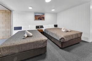 a bedroom with two beds with pillows on them at Bendigo Motor Inn in Bendigo