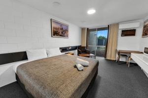 a bedroom with a large bed and a desk at Bendigo Motor Inn in Bendigo +37 photos