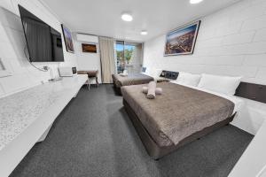 a bedroom with a large bed and a couch at Bendigo Motor Inn in Bendigo