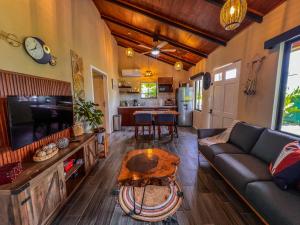 a living room with a couch and a table at House Monstera Arenal in Agua Azul