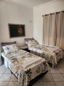 a room with two beds and a tv on the wall at Villa Mediterraneo in Beberibe +8 photos