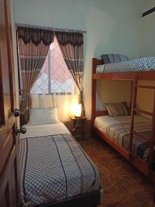 a bedroom with two bunk beds and a window at Home Capybara Stay in Mindo