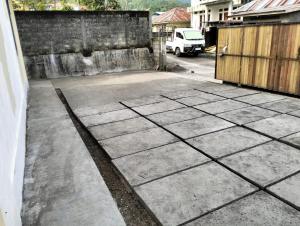 a concrete driveway with a fence and a building at Waceno Umma in Ruteng