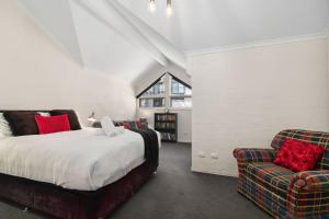 a bedroom with a bed and a couch and a chair at Inala 2 in Thredbo