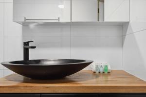 a black sink on a wooden counter in a bathroom at Inala 2 in Thredbo +22 photos