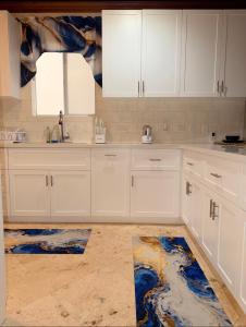 a kitchen with white cabinets and a blue rug at 4 story Ocean Villa in Nassau