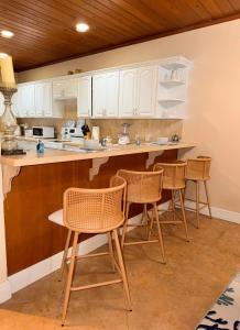 a kitchen with chairs and a counter with white cabinets at 4 story Ocean Villa in Nassau
