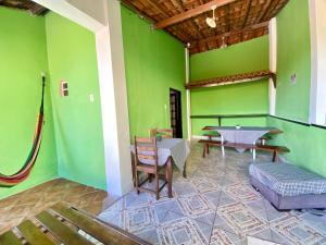 a room with green walls and a table and chairs at Visite Chapäda Hospedaria in Lençóis +71 photos