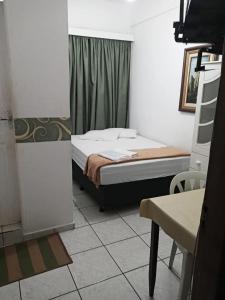 a small bedroom with a bed and a ladder at Palace Hotel in Anápolis