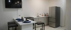 a kitchen with a refrigerator and a table and chairs at MayaVilla in Long Swamp