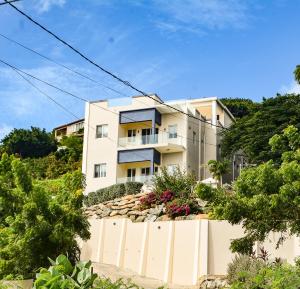 a white house with a fence in front of it at MayaVilla in Long Swamp
