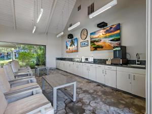 a kitchen with white cabinets and a clock on the wall at Kaanapali Alii 2 Bedroom Ocean View in Kaanapali