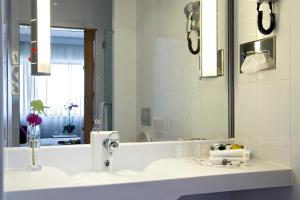 a bathroom with a sink and a mirror at Novotel Porto Gaia in Vila Nova de Gaia