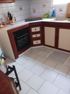 a kitchen with a stove and a white tile floor at Les Tourterelles in Sainte-Luce +5 photos