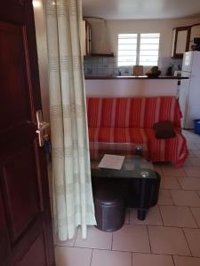 a living room with a red couch and a table at Les Tourterelles in Sainte-Luce