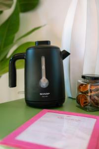 a black toaster sitting on a table with a paper at Baan Samsa in Luang Prabang