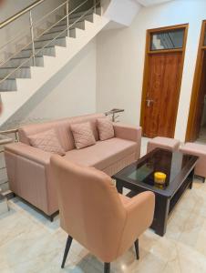 a living room with a couch and a table and stairs at Shivganga viila in Varanasi
