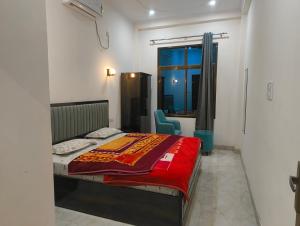 a bedroom with a bed with a red blanket on it at Shivganga viila in Varanasi