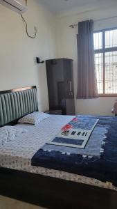a bedroom with a bed with a blue blanket on it at Shivganga viila in Varanasi