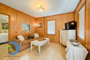 a living room with a couch and a tv at Cg Beach Bungalow #3 in Myrtle Beach