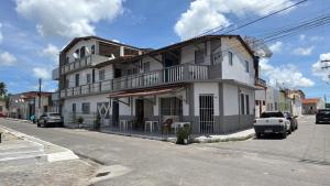 a white building on the side of a street at Pousada O Leão in Piaçabuçu