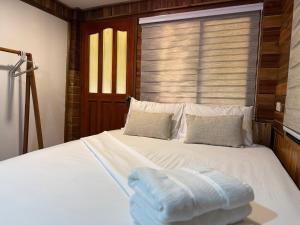 a bedroom with a bed with two towels on it at Leianna House in Itaytay