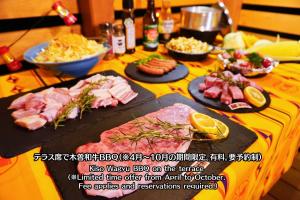 a table with meat and other food on it at Riverside Oasis WAKUWAKU-BASE in Yabuhara
