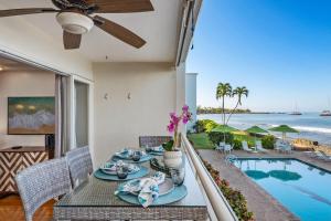 a dining room with a table and a view of the ocean at Lahaina Roads 209 in Lahaina