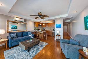 a living room with two blue couches and a table at Lahaina Roads 209 in Lahaina