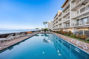 a swimming pool in front of a hotel with the ocean at Lahaina Roads 209 in Lahaina