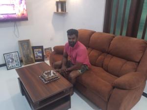 a man sitting on a couch next to a coffee table at ADOBE AFFECTIOn in Tangalle
