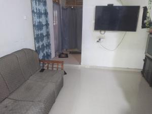 a living room with a couch and a flat screen tv at ADOBE AFFECTIOn in Tangalle