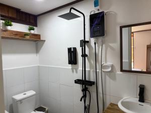 a shower in a bathroom with a toilet and a mirror at Leianna House in Itaytay +40 photos
