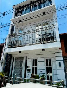 a white building with a balcony on top of it at Gray Room The White Haven In Clark in Angeles