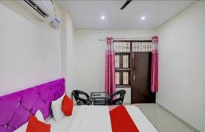 a room with a bed and chairs in it at Gold Hotel in Faridabad