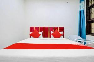 a bedroom with a large bed with red pillows at Gold Hotel in Faridabad +7 photos