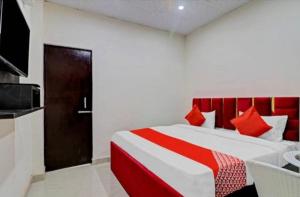 a bedroom with a large bed with a red headboard at Gold Hotel in Faridabad