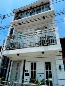 a white building with a balcony on top of it at The White Haven In Clark ENTIRE HOUSE in Angeles