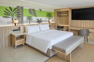 a bedroom with a large white bed and a flat screen tv at LIME Resort Bohol, a member of Radisson Individuals Premier in Panglao Island +105 photos