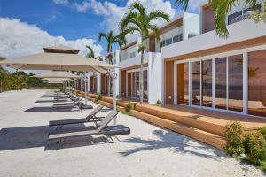 a row of chairs and umbrellas next to a building at LIME Resort Bohol, a member of Radisson Individuals Premier in Panglao Island
