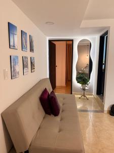 a living room with a couch and a mirror at Casa Bella Apartamentos in Cali