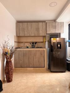 a kitchen with a stainless steel refrigerator and a vase at Casa Bella Apartamentos in Cali